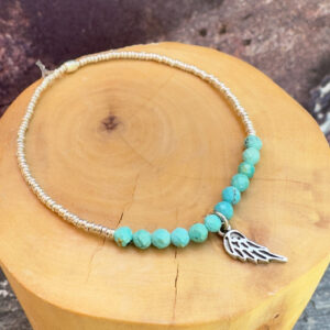 pulsera elasticada con medalla diseño alita hecha de plata 950, mostacillas de plata 1000 y piedras cuarzo rosa