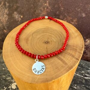 pulsera elasticada con medalla diseño gracias hecha de plata 950 con mostacillas de cristal rojo