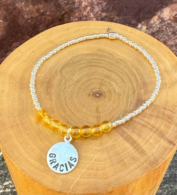 pulsera elasticada con medalla diseño gracias hecha de plata 950, mostacillas de plata 1000 y piedras citrino