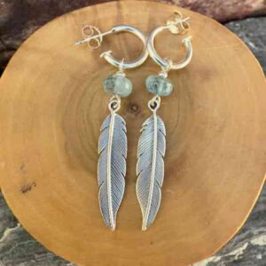 Aros de plata pura con dije de argollas y plumas acompañado de piedra aguamarina