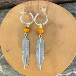Aros de plata pura con dije de argollas y plumas acompañado de piedra ambar.