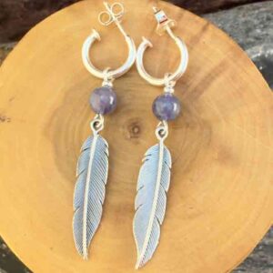 Aros de plata pura con dije de argollas y plumas acompañado de piedra tanzanita.