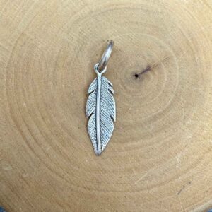 medalla hecha de plata 950 con diseño de pluma chica.