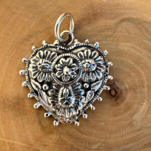 medalla hecha de plata 950 con diseño de corazon con flores.