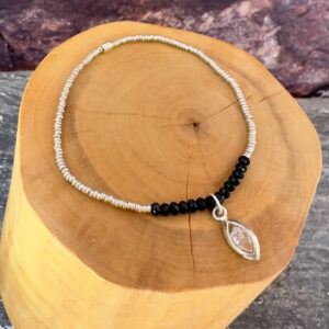 pulsera elasticada con mostacillas de plata 1000 y piedras turmalina negra, con un centro de cuarzo herkimer y plata 950