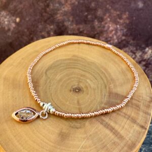 pulsera elasticada con mostacillas de plata 1000 y cobre, con un centro de cuarzo herkimer y cobre
