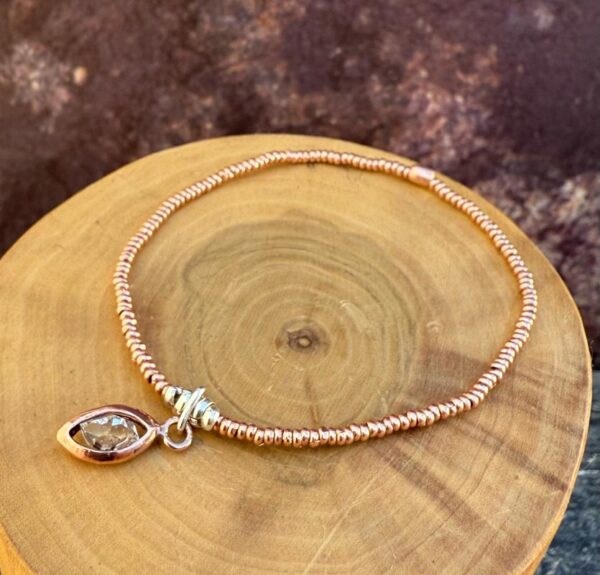 pulsera elasticada con mostacillas de plata 1000 y cobre, con un centro de cuarzo herkimer y cobre
