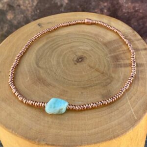pulsera elasticada con mostacillas de cobre, con una piedra central de Larimar