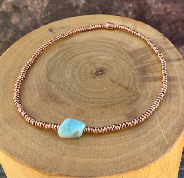 pulsera elasticada con mostacillas de cobre, con una piedra central de Larimar