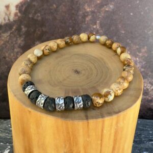 Pulsera elasticada formada con un centro mostacillas anchas de plata texturizada con martilladas interlineadas con mostacillas de piedra volcanica negra en su centro. completa el conjunto mostacillas de piedra jaspe amarillo