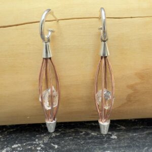 Aros tipo argolla hecho de plata 950, donde cuelga una jaulita hecha de cobre que contiene una piedra herkimer de 3 centimetros de diametro