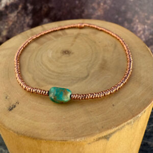 pulsera elasticada con mostacillas de cobre, con una piedra central de Larimar