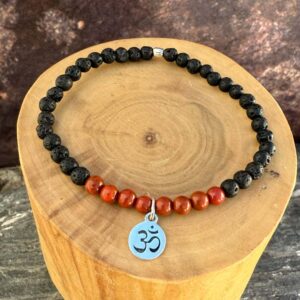 pulsera elasticada con mostacillas de jaspe y piedra volcanica, con una medalla central de plata 950 con simbolo OM