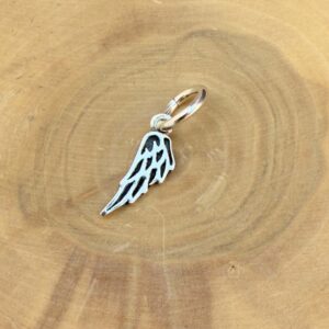 Medalla con diseño de Ala, hecha de plata 950 posada sobre un tronco