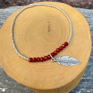 pulsera elasticada con mostacillas de cristal rojo y plata 1000, con medalla de diseño de pluma hecha de plata 950