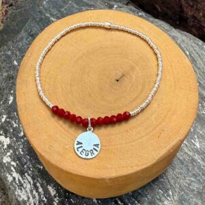 pulsera elasticada con mostacillas de cristal rojo y plata 1000, con medalla circular con la palabra alegria grabada, hecha de plata 950