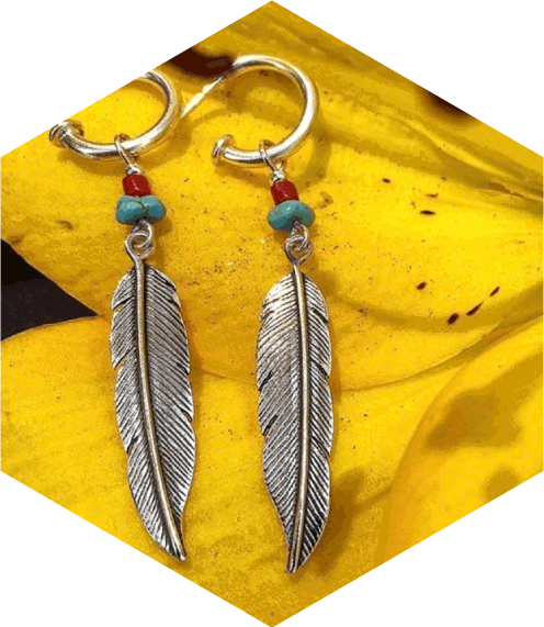 Aros diseño de pluma sobre pétalos amarillos