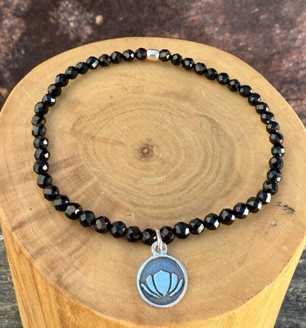 pulsera elasticada con medalla de plata 950 flor de loto y mostacillas de turmalina negra