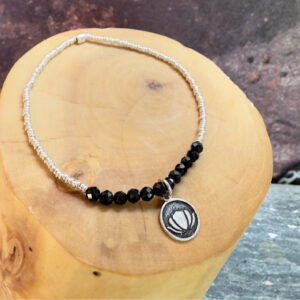 pulsera elasticada con medalla de plata 950 flor de loto, mostacillas de plata 1000 y piedras de turmalina negra