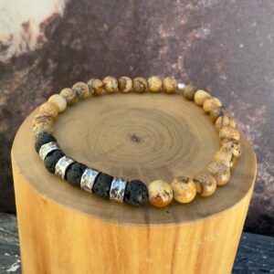 Pulsera elasticada formada con un centro mostacillas de plata texturizada con martillo interlineadas con mostacillas de piedra volcanica negra en su centro. completa el conjunto mostacillas de piedra jaspe amarillo