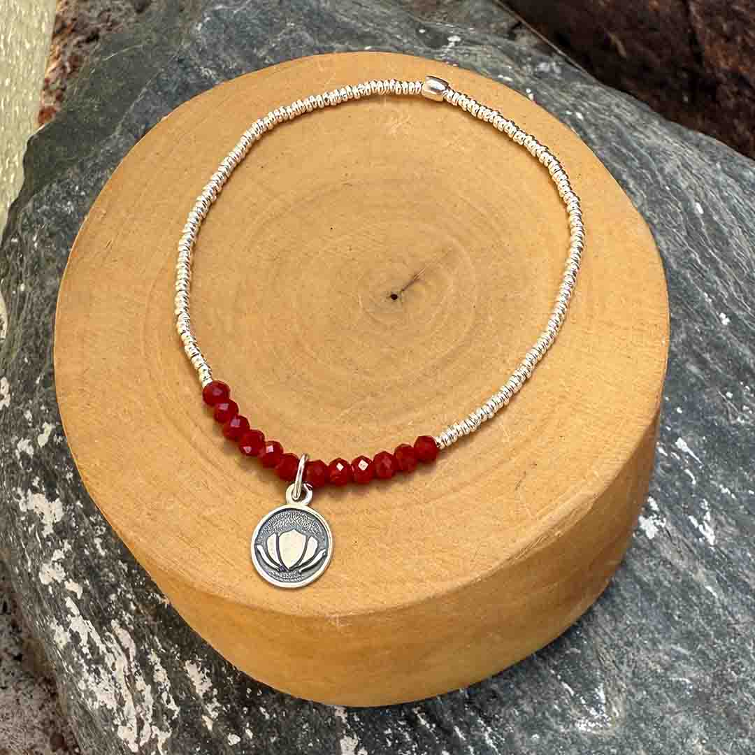 pulsera elasticada con medalla de plata 950 flor de loto, mostacillas de plata 1000 y piedras de cristal rojo